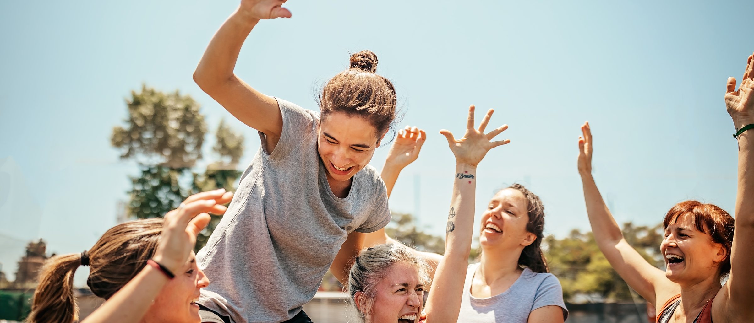 Frauen einer Sportmannschaft jubeln gemeinsam auf dem Platz